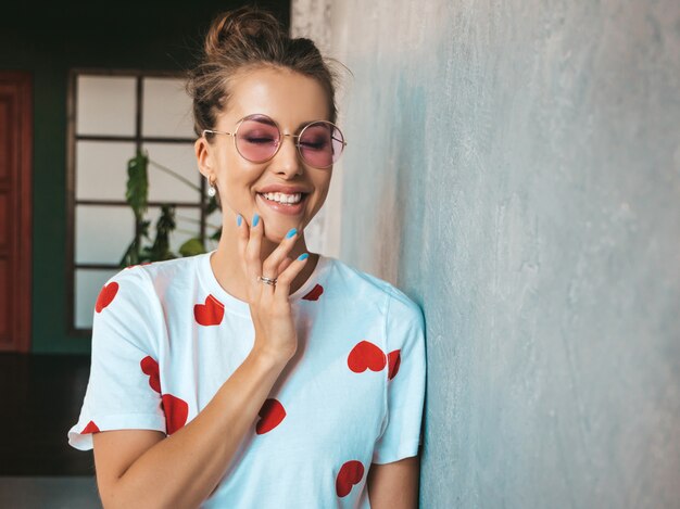 Portrait de belle jeune femme regardant la caméra fille à la mode en t-shirt blanc d'été décontracté