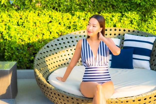 Portrait belle jeune femme se détendre sourire loisirs en vacances autour de la piscine dans l'hôtel de villégiature