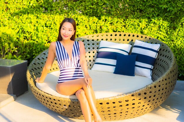 Portrait belle jeune femme se détendre sourire loisirs en vacances autour de la piscine dans l'hôtel de villégiature