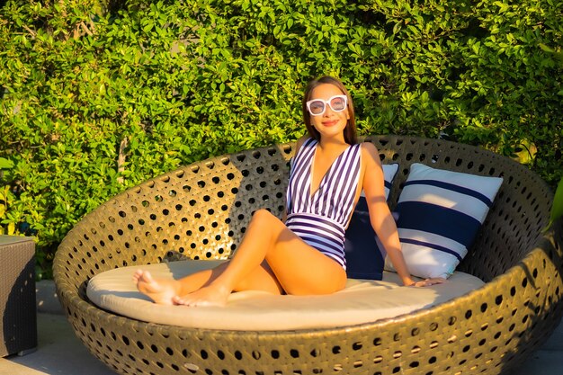 Portrait belle jeune femme se détendre sourire loisirs en vacances autour de la piscine dans l'hôtel de villégiature