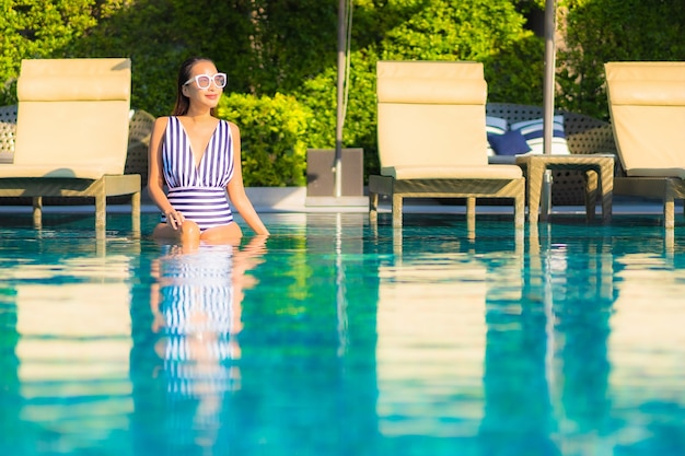 Photo gratuite portrait belle jeune femme se détendre sourire loisirs en vacances autour de la piscine dans l'hôtel de villégiature