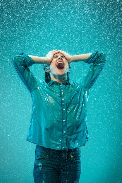 Le portrait de la belle jeune femme sous la pluie