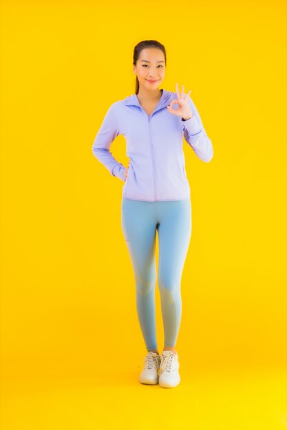 Portrait belle jeune femme sport asiatique prête pour l'exercice sur jaune