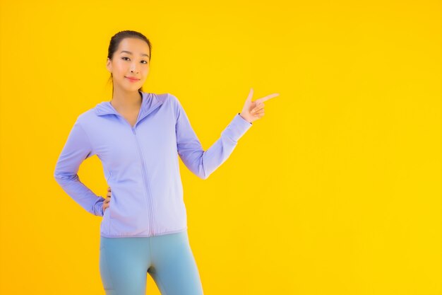 Portrait belle jeune femme sport asiatique prête pour l'exercice sur jaune