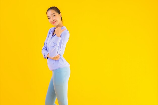 Portrait belle jeune femme sport asiatique prête pour l'exercice sur jaune