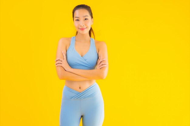 Portrait belle jeune femme sport asiatique prête pour l'exercice sur jaune