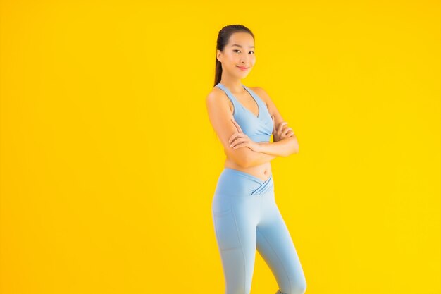 Portrait belle jeune femme sport asiatique prête pour l'exercice sur jaune