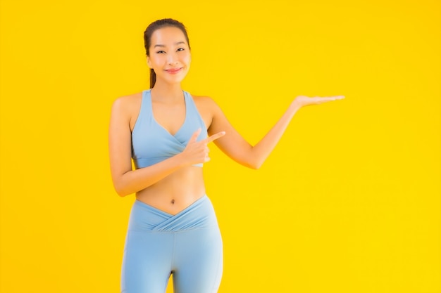 Portrait belle jeune femme sport asiatique prête pour l'exercice sur jaune