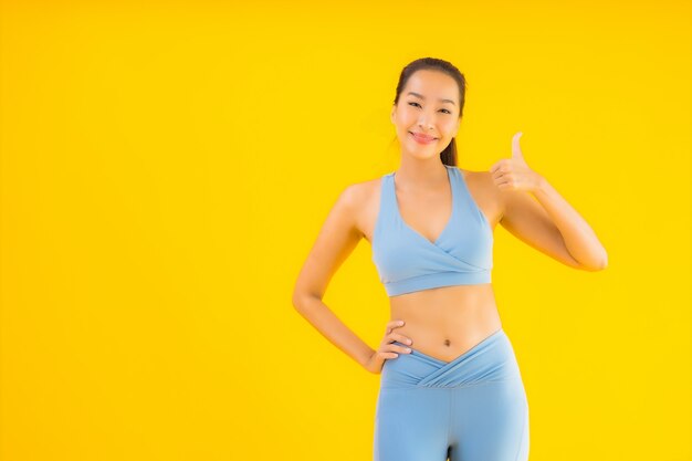 Portrait belle jeune femme sport asiatique prête pour l'exercice sur jaune