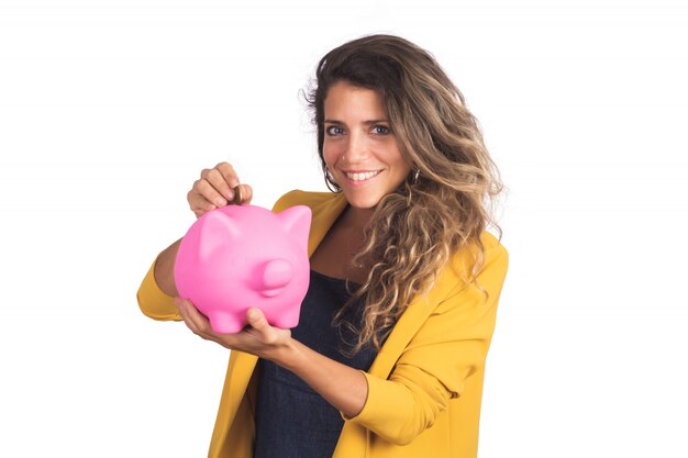 Portrait de la belle jeune femme tenant une tirelire sur studio. Économisez de l'argent.