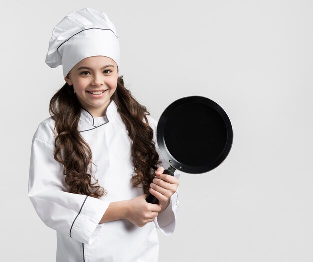 Portrait de la belle jeune fille tenant la casserole de cuisson