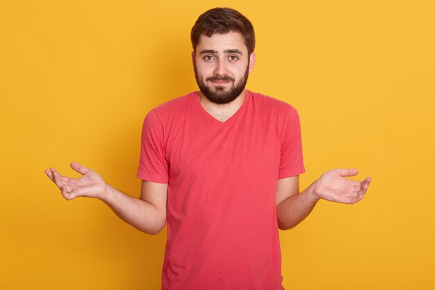 Portrait de la belle jeune homme barbu caucasien aux cheveux noirs, beau mâle regardant directement la caméra avec émotion confuse