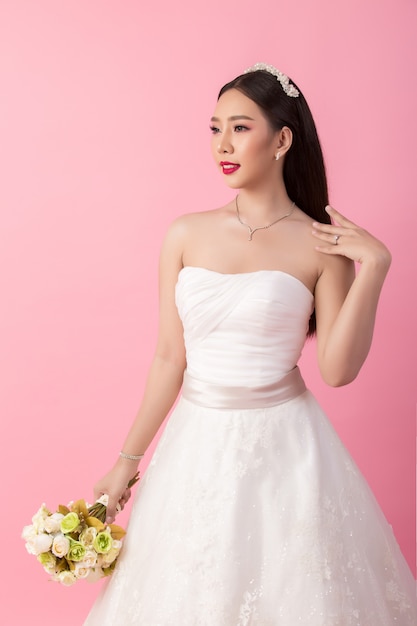 Portrait de la belle mariée asiatique en studio rose