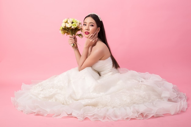 Portrait de la belle mariée asiatique en studio rose