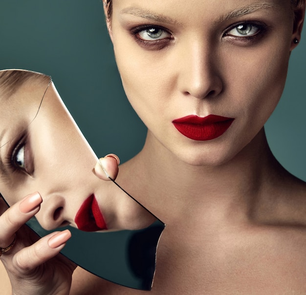 Portrait de la belle mode élégante femme brune modèle avec maquillage de soirée et lèvres rouges en veste blanche