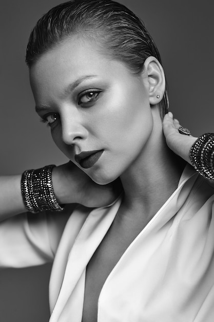 Portrait de la belle mode élégante femme brune modèle avec maquillage de soirée et lèvres rouges en veste blanche