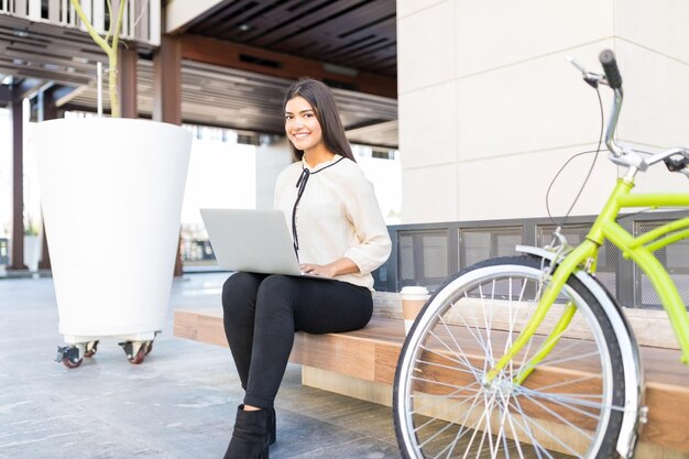 Portrait d'une belle travailleuse organisant des fichiers sur un ordinateur portable pendant son temps libre