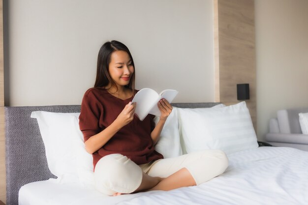 Portrait de belles jeunes femmes asiatiques lecture livre sur lit