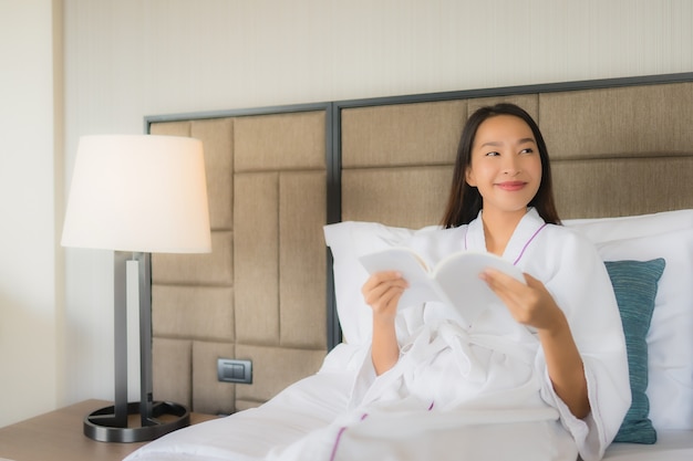 Portrait de belles jeunes femmes asiatiques avec livre sur lit