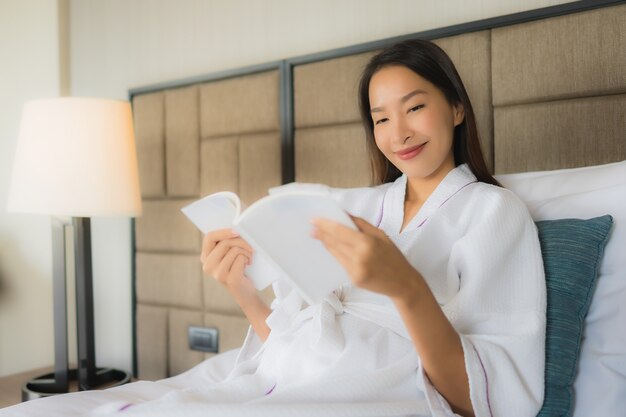 Portrait de belles jeunes femmes asiatiques avec livre sur lit