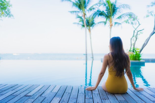 Portrait de belles jeunes femmes asiatiques sourire heureux se détendre autour de la piscine extérieure