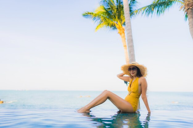 Portrait de belles jeunes femmes asiatiques sourire heureux se détendre autour de la piscine extérieure