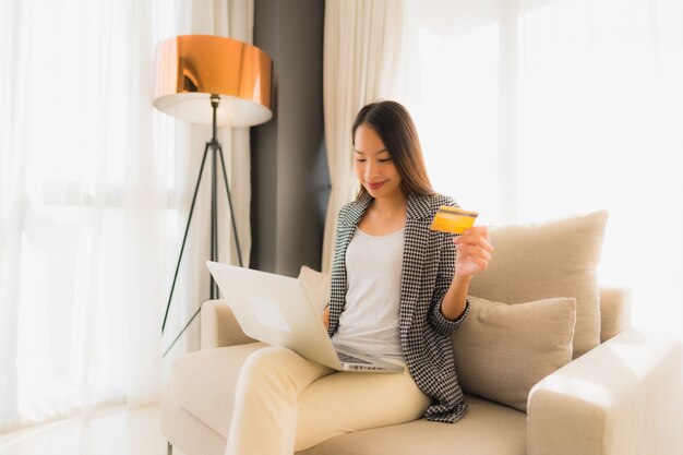 Portrait de belles jeunes femmes asiatiques utilisant un ordinateur portable ou un téléphone intelligent et mobile avec carte de crédit pour faire du shopping en ligne