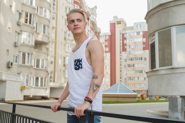 Portrait blond hipster garçon avec des tatouages et des cheveux élégants
