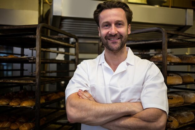 Portrait de boulanger debout avec les bras en souriant traversa