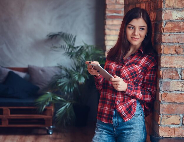 Portrait d'une charmante brune dans une chemise en flanelle et un jean d'esprit