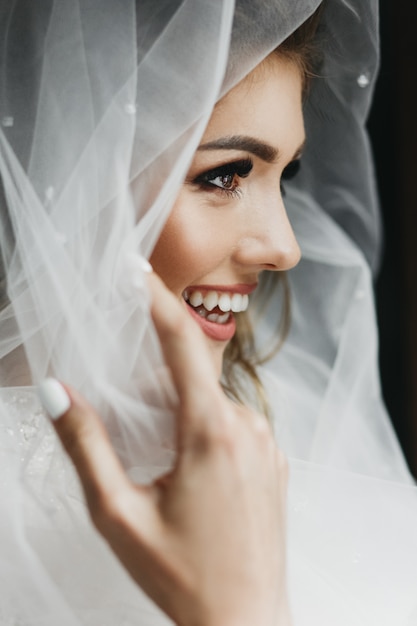 Photo gratuite portrait de la charmante mariée enveloppée dans un voile