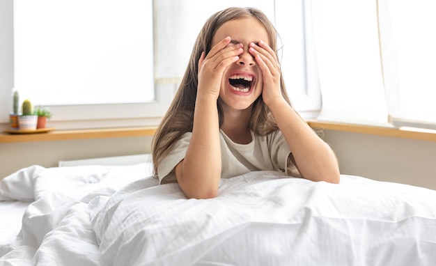 Portrait d'une charmante petite fille au lit tôt le matin