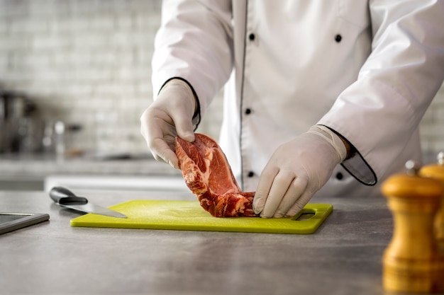 Portrait de chef masculin dans la cuisine préparant la viande