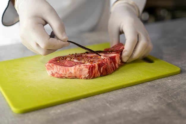 Photo gratuite portrait de chef masculin dans la cuisine préparant la viande