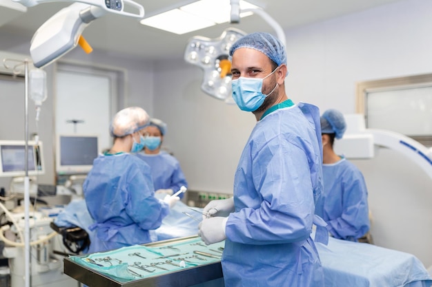 Portrait d'un chirurgien homme heureux debout dans la salle d'opération prêt à travailler sur un patient Travailleur médical masculin en uniforme chirurgical en salle d'opération