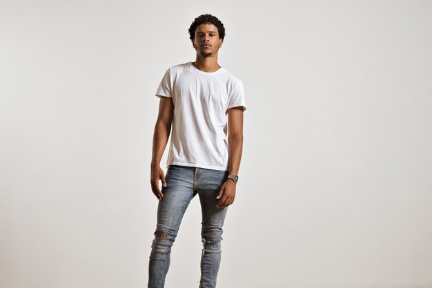 Portrait complet du corps d'un jeune homme athlétique en jean bleu clair déchiré et t-shirt blanc à manches courtes