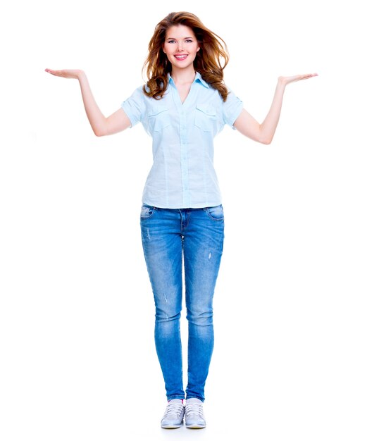 Portrait complet d'une femme heureuse avec un geste de présentation sur fond blanc.