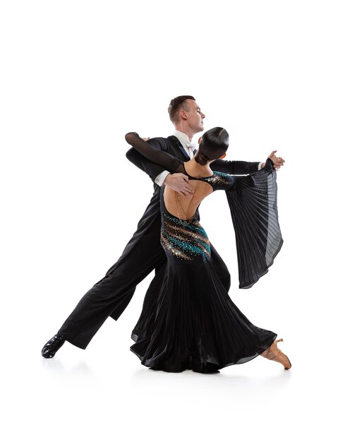 Portrait complet d'un jeune couple pratiquant la danse de salon isolé sur fond de studio blanc