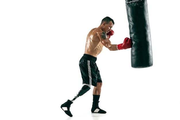 Photo gratuite portrait complet d'un sportif musclé avec jambe prothétique, espace de copie. boxer masculin en gants rouges s'entraînant et s'exerçant. isolé sur mur blanc. concept de sport, mode de vie sain.