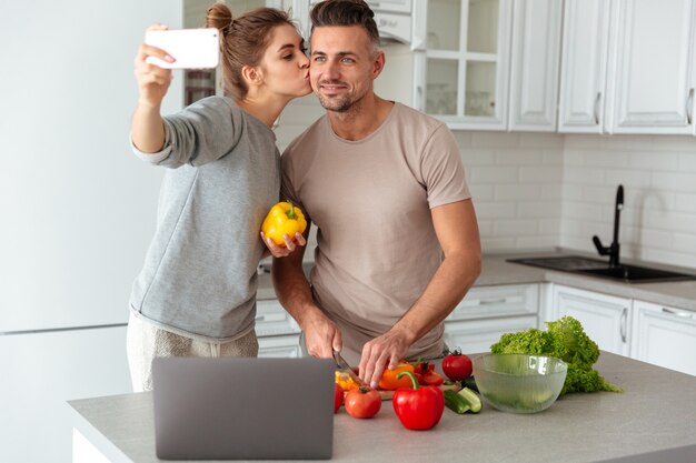 Portrait d'un couple d'amoureux heureux cuisiner ensemble la salade