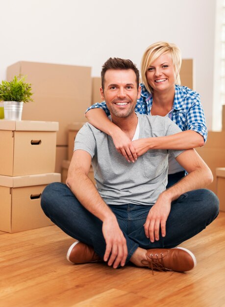 Portrait de couple assis dans une nouvelle maison