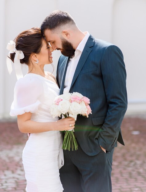 Portrait d'un couple attrayant et heureux se touchant et s'étreignant en appréciant leur relation tout en se tenant à l'extérieur