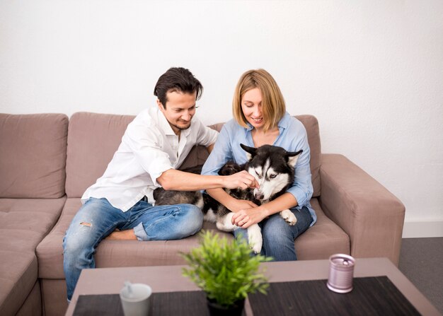 Portrait de couple heureux à la maison avec chien