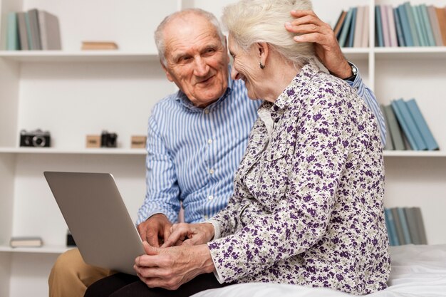 Portrait de couple de personnes âgées à l'aide d'un ordinateur portable