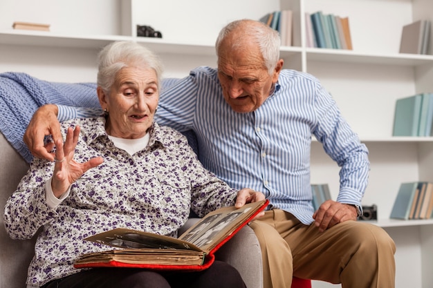 Portrait de couple de personnes âgées avec album photo