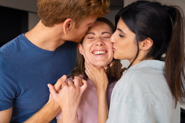 Portrait de couple polyamoureux à la maison montrant de l'affection