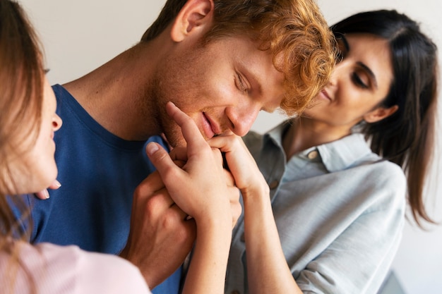 Portrait de couple polyamoureux à la maison montrant de l'affection