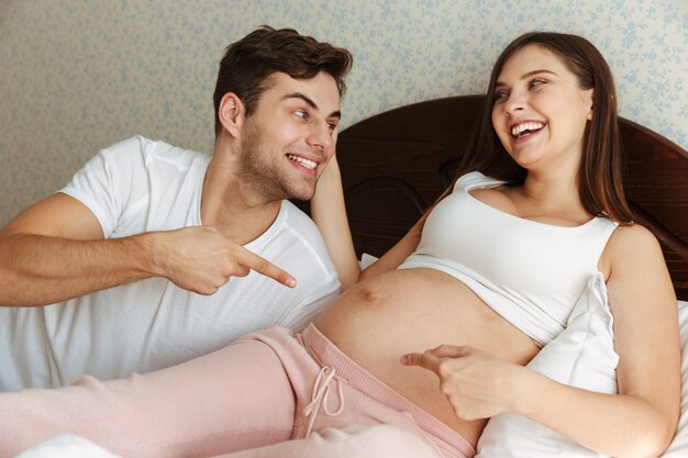 Portrait d'un couple souriant heureux, pointant les doigts