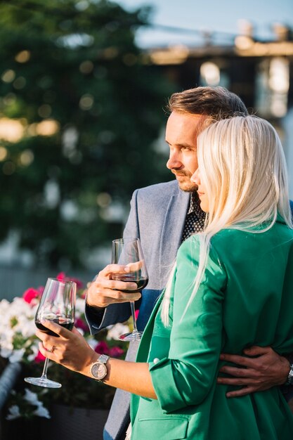 Portrait de couple tenant des verres à vin embrassant