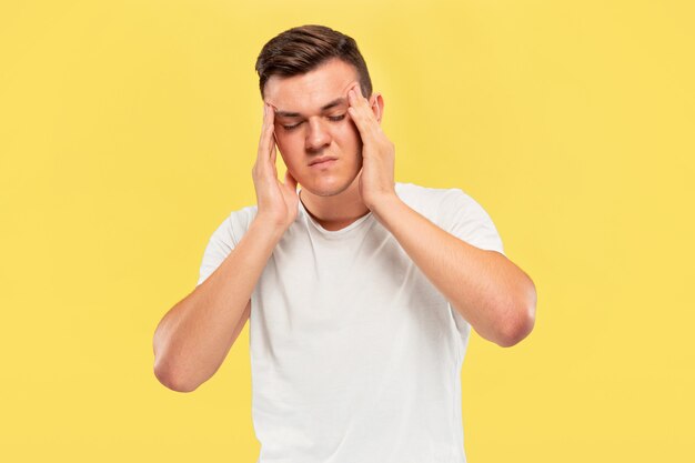 Portrait demi-longueur du jeune homme caucasien sur jaune